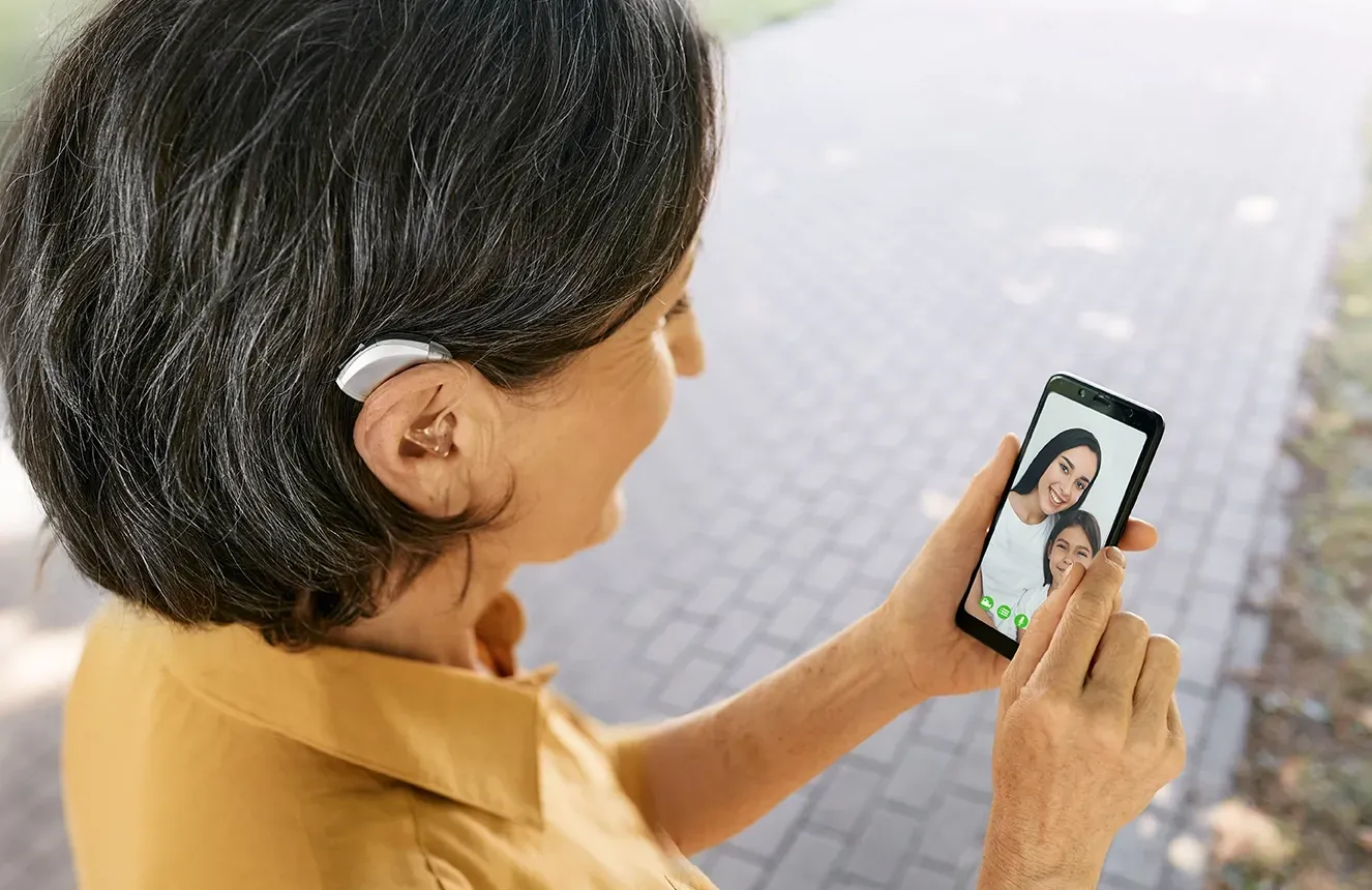 femme-portant-un-appareil-auditif-au-telephone-en-famille